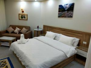 - une chambre avec un grand lit et un canapé dans l'établissement Happy Home, à Hurghada