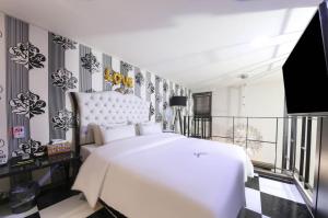 1 dormitorio con cama blanca y suelo blanco y negro en Jeonju Stay Hotel, en Jeonju