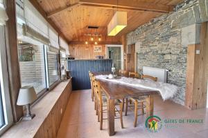 une salle à manger avec une grande table et des chaises en bois dans l'établissement Chambres d'hôtes - Au Domaine des Camélias, à Pluméliau