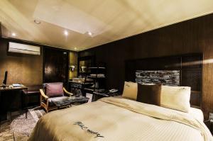 1 dormitorio con cama, escritorio y silla en Jeonju Stay Hotel, en Jeonju