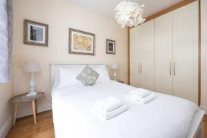una camera da letto con un grande letto bianco e un lampadario a braccio di Artist's CENTRAL apartment! a Dublino