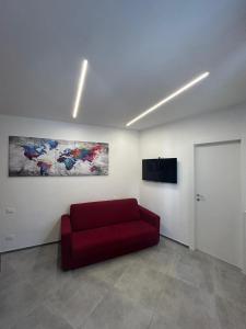een woonkamer met een rode bank en een flatscreen-tv bij J. Suite in Castel di Sangro
