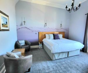 1 dormitorio con 1 cama grande y 1 silla en Straven Guesthouse, en Edimburgo