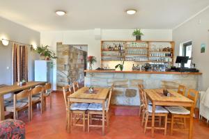 un restaurante con mesas y sillas de madera y un bar en Penzion Kairos, en Klokočí