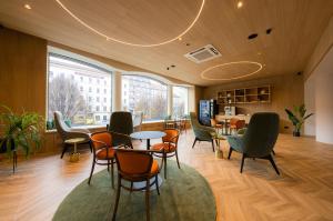 un bureau avec des chaises, des tables et une grande fenêtre dans l'établissement Hotel Beránek, à Prague