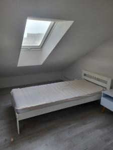 Bett in einem weißen Zimmer mit Fenster in der Unterkunft Ferienhaus Nikita in Würzburg