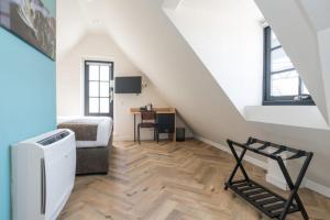 a attic room with a staircase with a bed and a desk at Hof van Holland Hotel in Edam