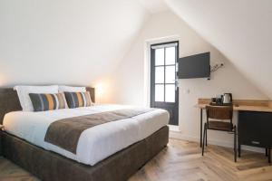 a bedroom with a bed and a desk with a computer at Hof van Holland Hotel in Edam +38 photos