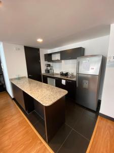 a kitchen with a counter top and a refrigerator at Aqua Loft in Quito