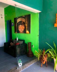 a living room with a green wall with a painting at Pousada Fortaleza in Fortaleza