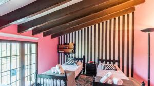 2 camas en una habitación con paredes rosas en Cortijo la Dehesa Villanueva del Trabuco by Ruralidays en Villanueva del Trabuco
