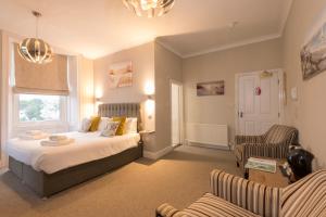 a bedroom with a bed and two chairs at Sure Hotel Collection by Best Western Porth Veor Manor Hotel in Newquay