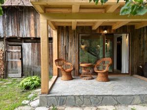 un patio con 3 sillas de mimbre y una mesa en Casa de vacanta traditionala La Fanar, en Schiuleşti