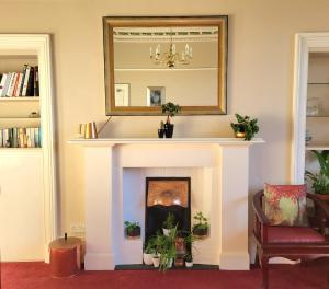 a living room with a fireplace with a mirror at Straven Guesthouse in Edinburgh