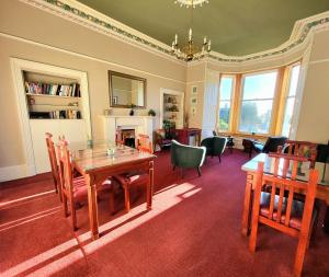 un soggiorno con tavolo e sedie in legno di Straven Guesthouse a Edimburgo