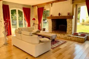 a living room with a couch and a fireplace at Magnificent 17th property calm and relaxation in Bailleau-lʼÉvêque