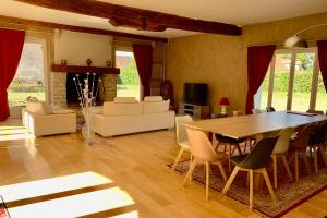 een woonkamer met een eettafel en stoelen bij Magnificent 17th property calm and relaxation in Bailleau-lʼÉvêque