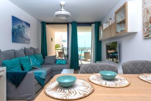 a living room with a table and a couch at Calypso II by Sea You There Fuerteventura in Cotillo