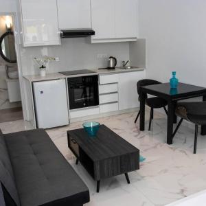 een woonkamer met een bank en een tafel en een keuken bij Nissi49 Apartments in Ayia Napa