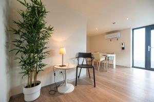 ein Wohnzimmer mit einem Tisch und einer Pflanze in der Unterkunft Hôtel Battice - Appart Hôtel in Herve