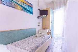 1 dormitorio con 1 cama y una pintura en la pared en Hotel Continental, en Bellaria-Igea Marina