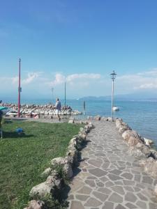 a stone walkway next to the water with a man walking on it at B&B Porte Rosse in Solferino