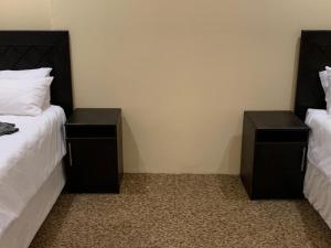a bedroom with two beds and two night stands at Tanzanite Guesthouse in Dannhauser