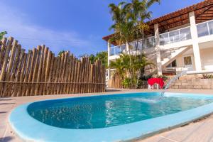 a swimming pool in front of a house at Pousada Três Praias in Guarapari