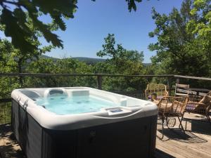 een hot tub op een terras met een tafel en stoelen bij Les Yourtes de Provence in Saint-Paulet-de-Caisson