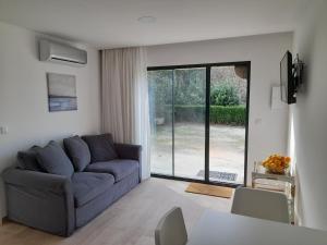 ein Wohnzimmer mit einem blauen Sofa und einem Fenster in der Unterkunft Casa/Apartamento de hóspedes in Viana do Castelo