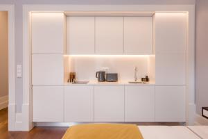 un placard blanc avec évier et four micro-ondes dans l'établissement Porto Almada 180 Apartments, à Porto