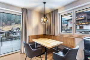 a dining room with a table and chairs and windows at Luisalle Top 4 in Auffach
