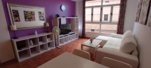 - un salon avec un canapé blanc et un mur violet dans l'établissement Apartamento "CASA LOS SABANDEÑOS", à Vecindario