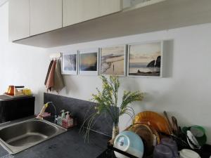 a kitchen with a sink and some pictures on the wall at A Peaceful Room at Barsacity Apartment by Ciputra in Seturan