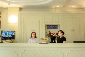 two women standing behind a counter in a room at Ivory Palace Hotel in Pattaya Central