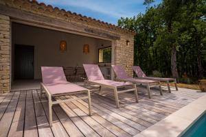 een groep stoelen op een terras naast een zwembad bij Stone charming villa pool and garden in Gordes in Gordes