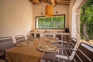 een eetkamer met een tafel en stoelen en een raam bij Stone charming villa pool and garden in Gordes in Gordes