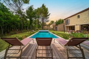 een patio met 2 stoelen en een zwembad bij Stone charming villa pool and garden in Gordes in Gordes