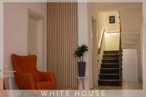 una sala de estar con una silla naranja y una casa blanca en White House en Tiflis