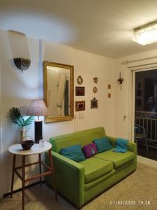 un sofá verde en una sala de estar con mesa en apartamento som do mar., en Fortaleza