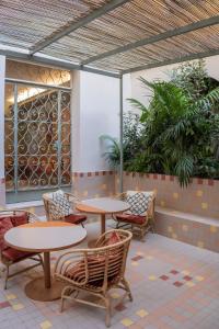 a patio with tables and chairs and plants at Hotel Milani in Rome