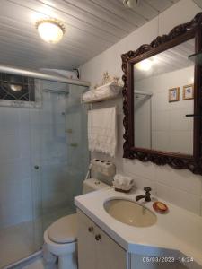 a bathroom with a sink and a toilet and a mirror at apartamento som do mar. in Fortaleza