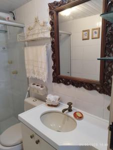 a bathroom with a sink and a mirror at apartamento som do mar. in Fortaleza