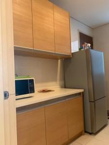 a kitchen with a microwave and a refrigerator at MARC RESIDENCE BY RED HOMES in Kuala Lumpur