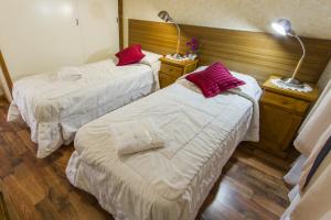 duas camas num quarto de hotel com almofadas vermelhas em Bed and Breakfast Aijpel em Ushuaia
