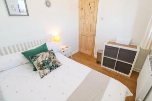a bedroom with a white bed and a television at Seagulls Retreat in Falmouth