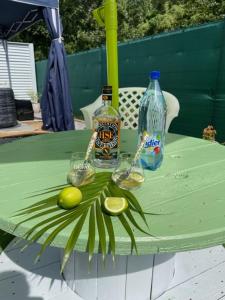 una mesa con dos botellas de alcohol y fruta. en Kay Sandra à 2 mn du CHU, en Saint-Joseph