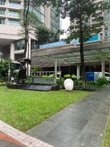 a park with a statue in front of a building at MARC RESIDENCE BY RED HOMES in Kuala Lumpur