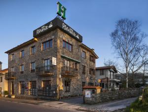 a building with a cross on the top of it at Hotel Restaurante Cabo Vidío in Oviñana