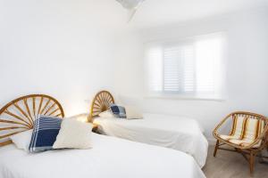 2 Betten in einem Zimmer mit 2 Stühlen und einem Fenster in der Unterkunft Coastal Hideaway in Puerto de Santiago